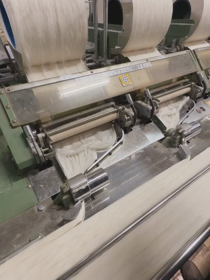 社内で栽培して収穫した綿花の綿と種を分ける作業を